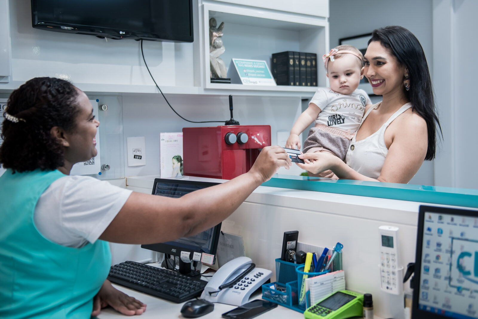 Atendimento a uma mãe com bebê na recepção da Clivped Linhares