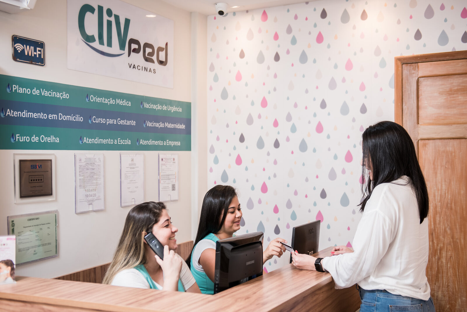 Recepção da Clivped Colatina Matriz, com o painel de serviços da clínica